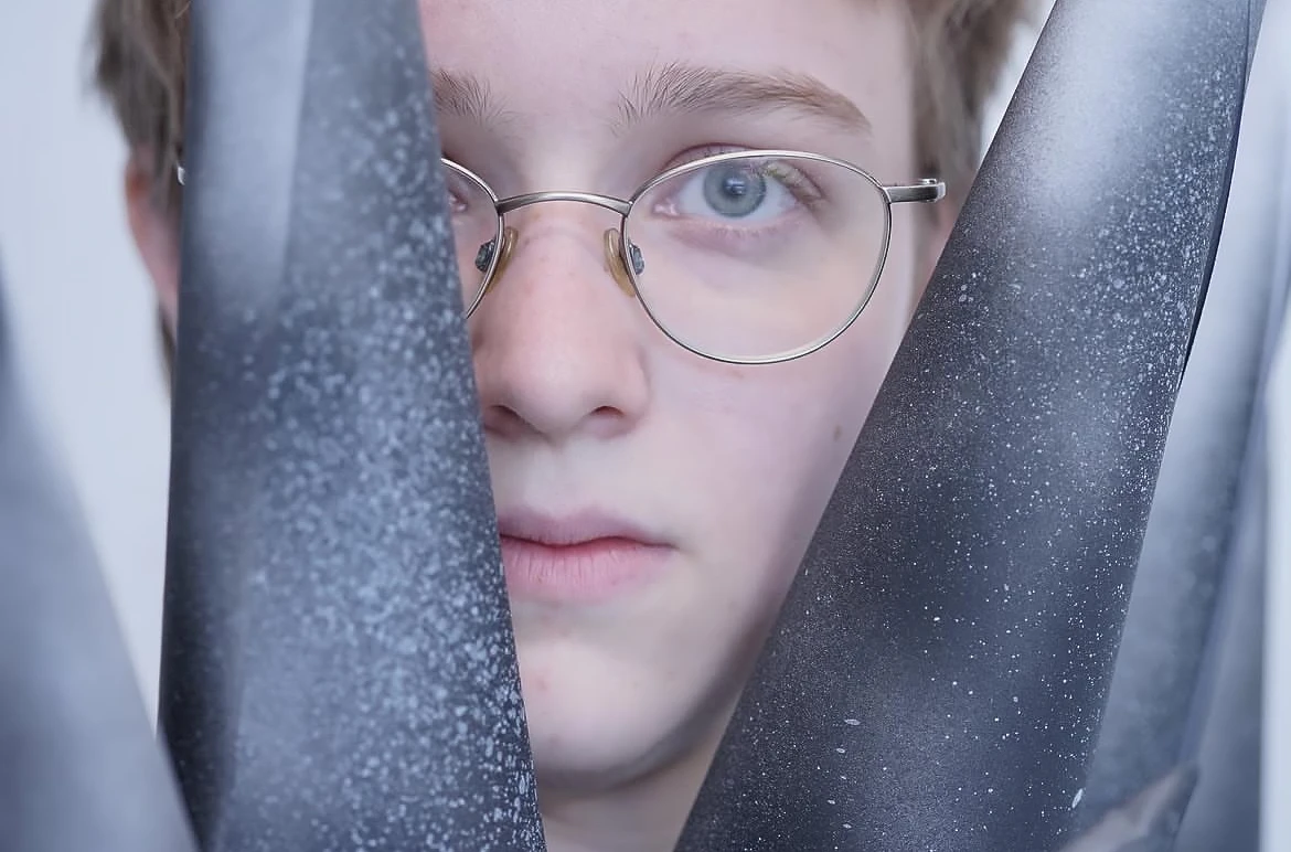 Woman standing behind paper spikes with fear in her eyes